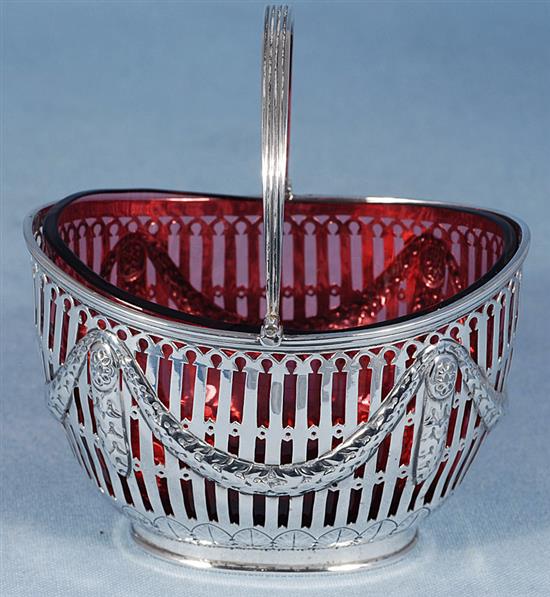 A Victorian silver swing handled sugar basket with cranberry glass liner, length 128mm, weight silver only 5.3oz/151grms